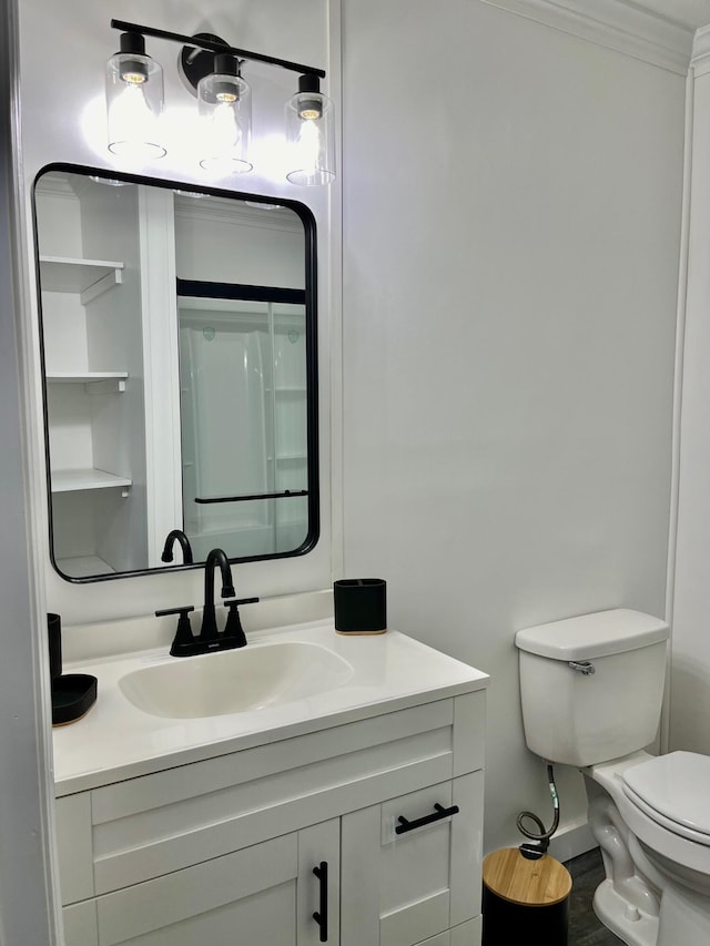 bathroom featuring vanity, toilet, and ornamental molding