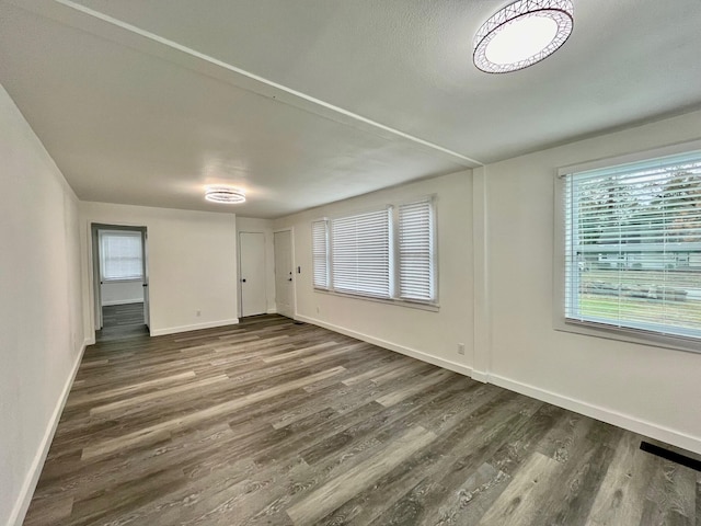 empty room with dark hardwood / wood-style flooring