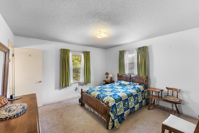 bedroom featuring light carpet and a textured ceiling