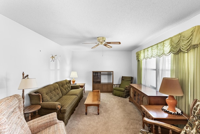 living room with ceiling fan, light carpet, and a textured ceiling