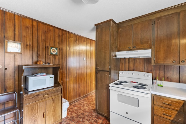 kitchen with white appliances and wood walls