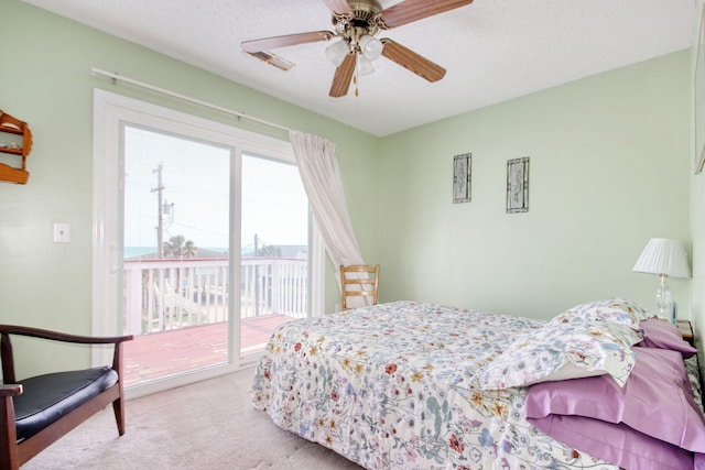 carpeted bedroom with access to outside, a ceiling fan, and visible vents