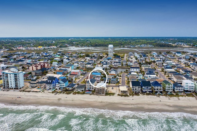 drone / aerial view featuring a beach view, a residential view, and a water view