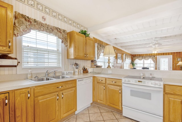 kitchen with beam ceiling, a sink, light tile patterned floors, white appliances, and a wealth of natural light