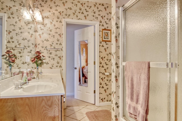 full bathroom featuring double vanity, wallpapered walls, tile patterned floors, a sink, and a stall shower