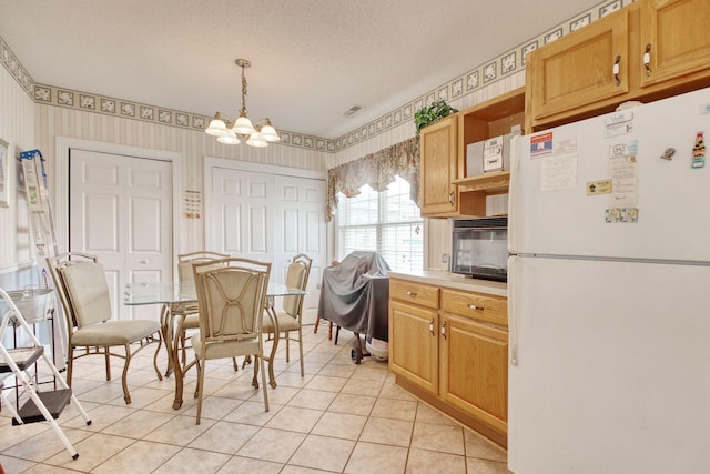 dining area with light tile patterned flooring, wallpapered walls, a notable chandelier, and a textured ceiling
