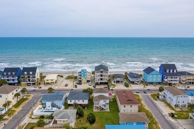 drone / aerial view featuring a residential view, a view of the beach, and a water view