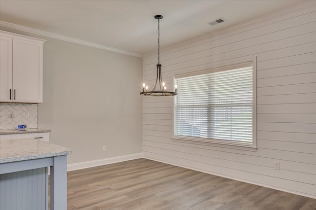 5265 Greyton Cir, North Augusta, SC 29860 - unfurnished dining area with wooden walls, ornamental molding, a chandelier, light wood-style floors, and baseboards