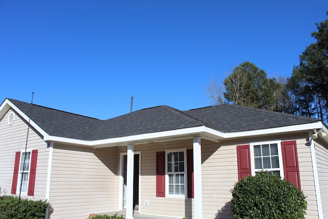 view of front of house with a shingled roof and a porch