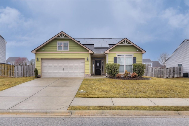 view of front of property featuring a garage, central AC unit, a front yard, and solar panels