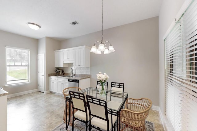 dining room with a chandelier and baseboards