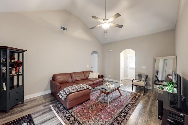 living room with arched walkways, a ceiling fan, wood finished floors, high vaulted ceiling, and baseboards