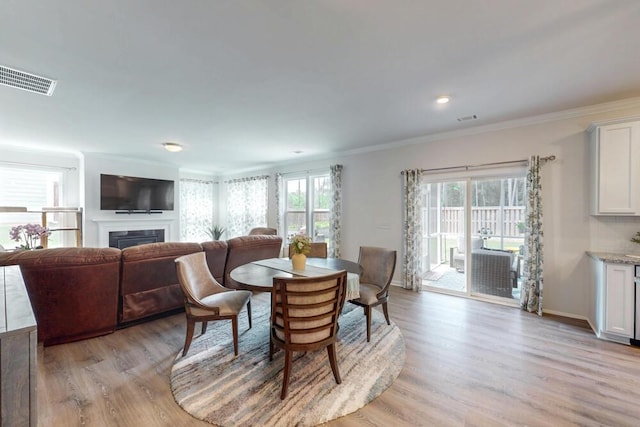 6134 High Top Ln, Aiken, SC 29801 - dining room with light wood-style floors, ornamental molding, a fireplace, and baseboards