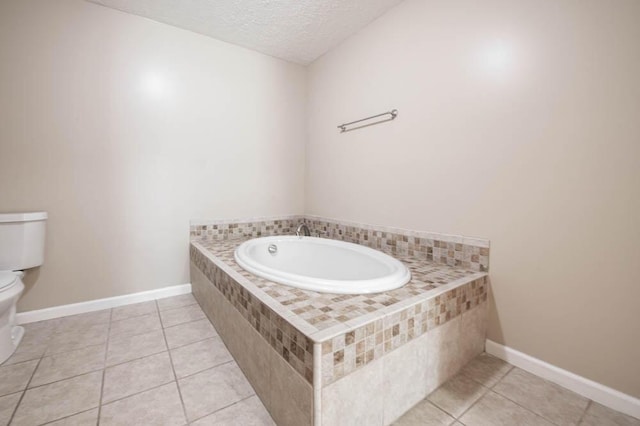 bathroom with tile patterned floors, a bathtub, a textured ceiling, and toilet