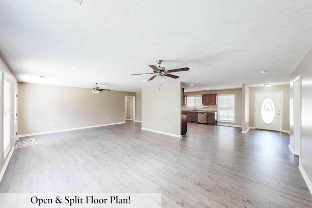 unfurnished living room with hardwood / wood-style flooring, sink, a textured ceiling, and ceiling fan