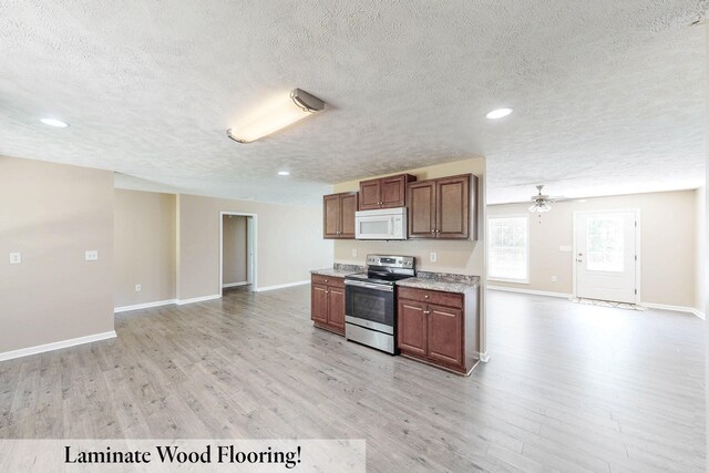 kitchen with a textured ceiling, ceiling fan, stainless steel range with electric stovetop, and light wood-type flooring