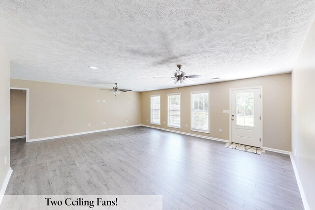 unfurnished living room with a textured ceiling, light hardwood / wood-style floors, and ceiling fan