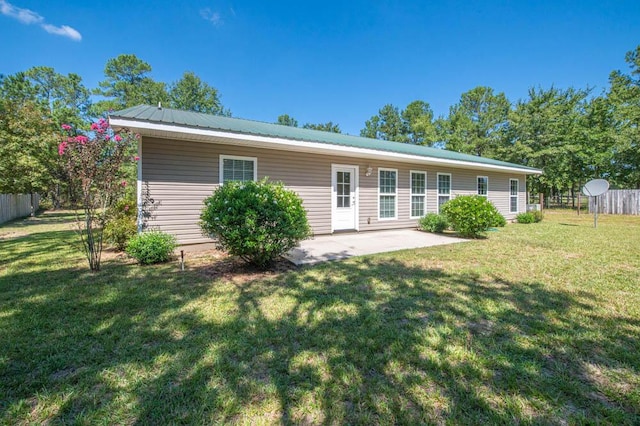 back of property with a lawn and a patio