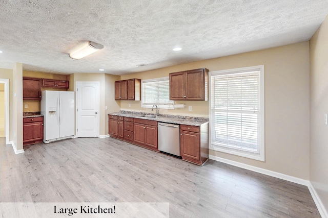 kitchen with sink, white refrigerator with ice dispenser, stainless steel dishwasher, a textured ceiling, and light hardwood / wood-style flooring