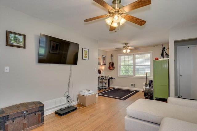living room with visible vents, a ceiling fan, baseboards, and wood finished floors