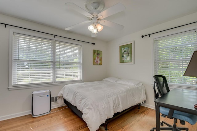 bedroom with a ceiling fan, baseboards, and light wood finished floors