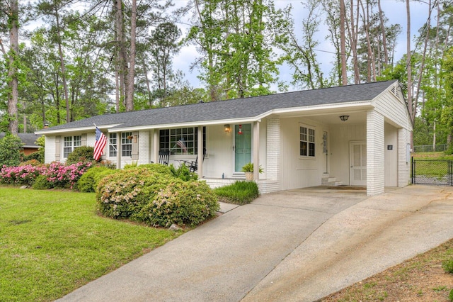 single story home with a front lawn, brick siding, an attached carport, concrete driveway, and covered porch