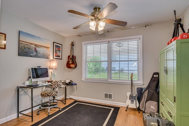 office featuring baseboards, ceiling fan, wood finished floors, and visible vents