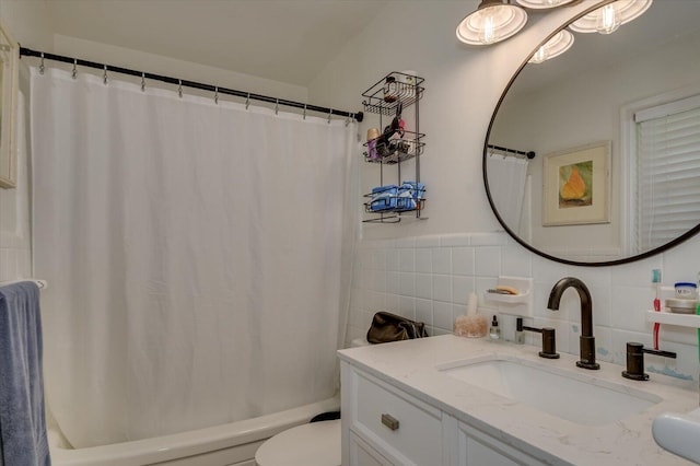 full bathroom with vanity, shower / bath combo with shower curtain, toilet, and tile walls