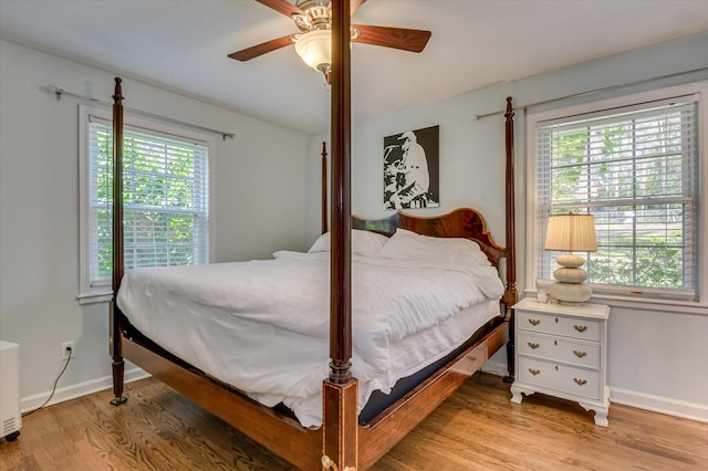 bedroom featuring light wood-style floors, baseboards, and ceiling fan