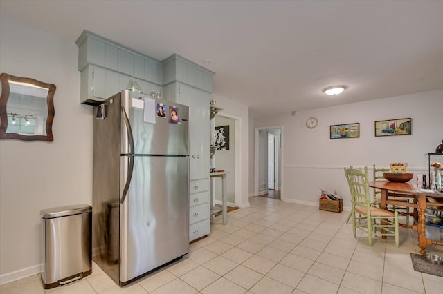 kitchen featuring baseboards, freestanding refrigerator, and light tile patterned flooring