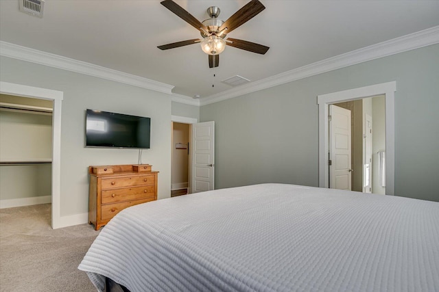 bedroom featuring light carpet, a spacious closet, ceiling fan, and ornamental molding