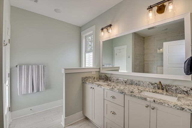 bathroom featuring a tile shower and vanity