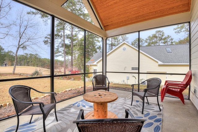 sunroom / solarium with vaulted ceiling, plenty of natural light, and wood ceiling