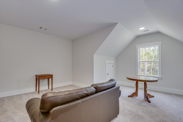 interior space with light colored carpet and vaulted ceiling