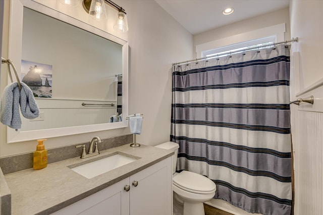 bathroom with curtained shower, vanity, and toilet