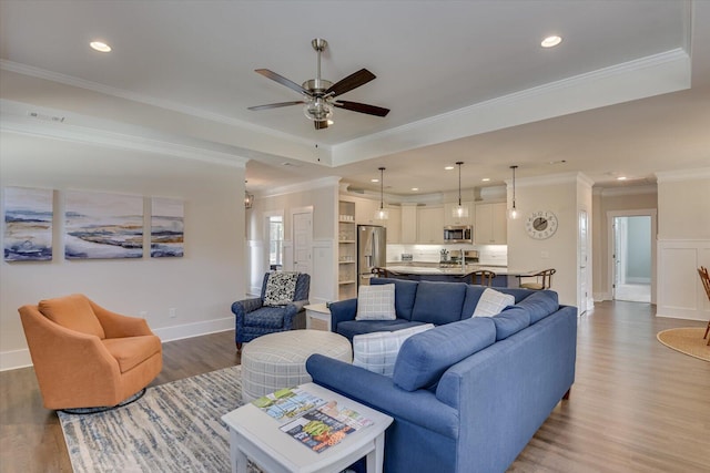 living room featuring dark hardwood / wood-style flooring, ceiling fan, and ornamental molding