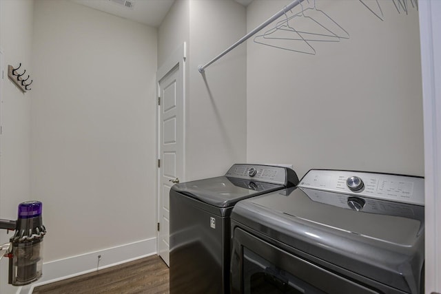 washroom with separate washer and dryer and dark hardwood / wood-style floors