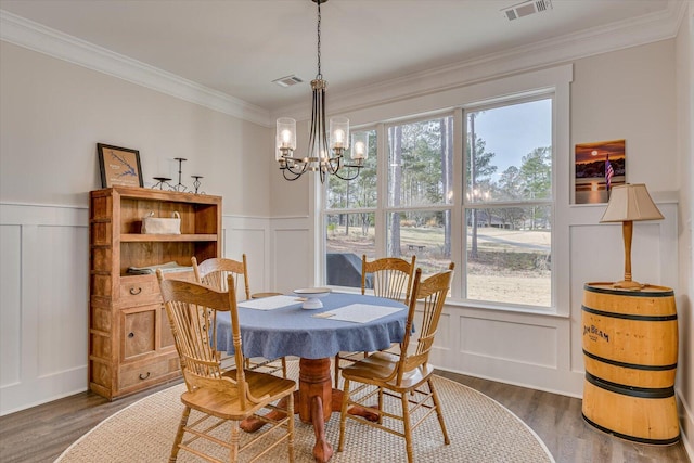 dining room with a chandelier, crown molding, a wealth of natural light, and dark wood-type flooring