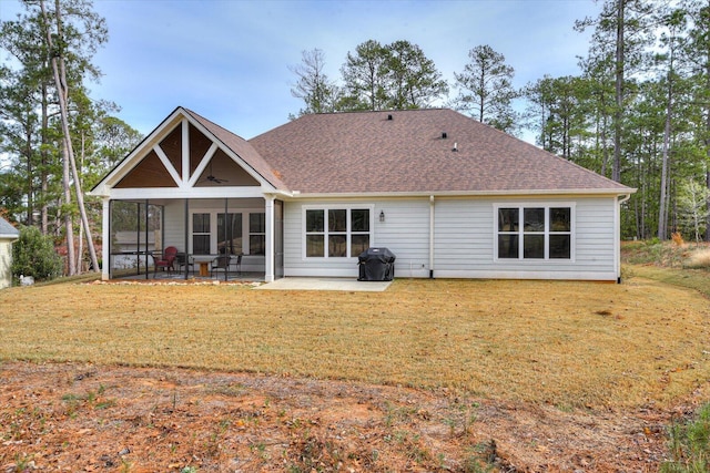 back of property with a yard, a patio area, and a sunroom