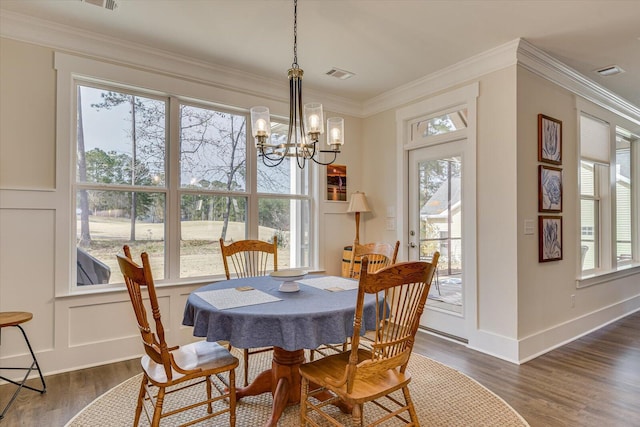 dining room with dark hardwood / wood-style floors, an inviting chandelier, and ornamental molding