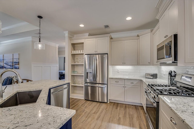 kitchen featuring pendant lighting, light stone countertops, sink, and appliances with stainless steel finishes