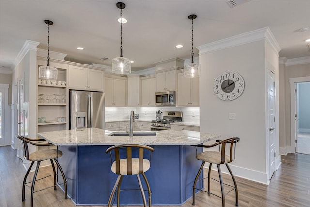 kitchen with a breakfast bar area, sink, hanging light fixtures, and appliances with stainless steel finishes