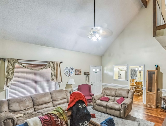 living room with a ceiling fan, wood finished floors, and high vaulted ceiling