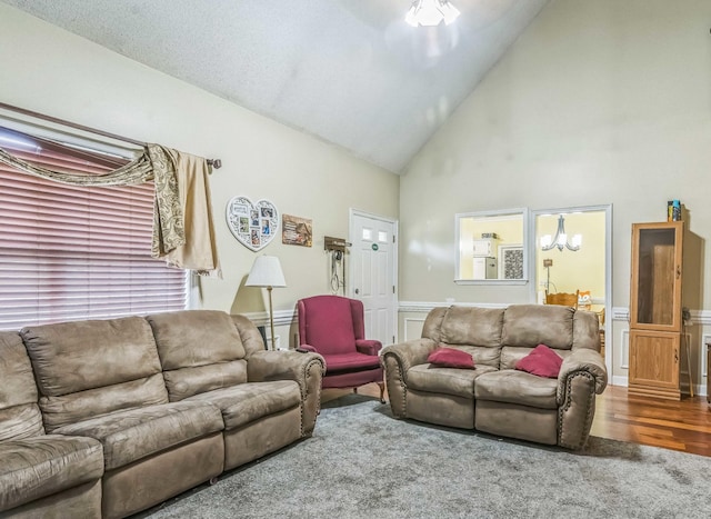 living area with high vaulted ceiling, carpet flooring, and a wainscoted wall