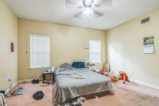 bedroom featuring carpet, a textured ceiling, baseboards, and ceiling fan