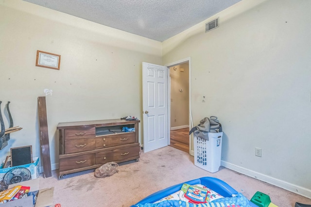 carpeted bedroom with a textured ceiling and baseboards