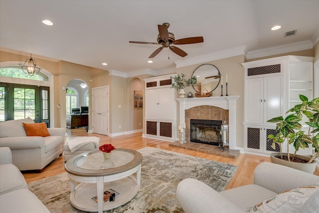 209 Apple Ln, Mccormick, SC 29835 - living room featuring arched walkways, light wood-type flooring, ceiling fan, ornamental molding, and a tile fireplace