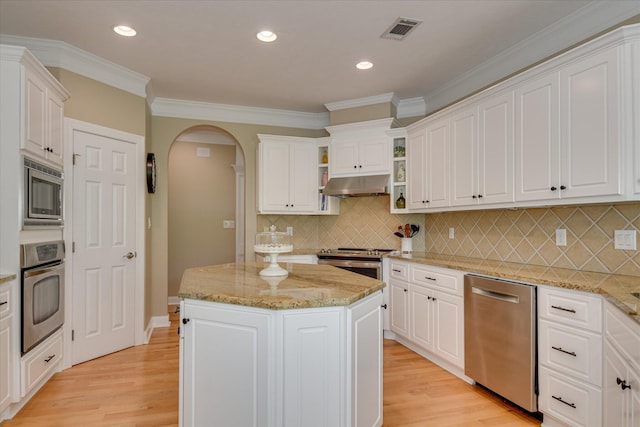 209 Apple Ln, Mccormick, SC 29835 - kitchen with stainless steel appliances, under cabinet range hood, arched walkways, white cabinetry, and ornamental molding