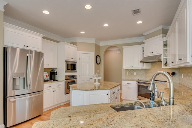 209 Apple Ln, Mccormick, SC 29835 - kitchen featuring stainless steel appliances, under cabinet range hood, arched walkways, white cabinetry, and ornamental molding