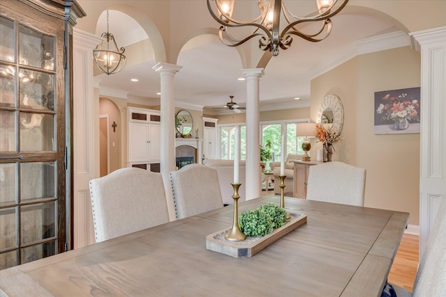 209 Apple Ln, Mccormick, SC 29835 - dining room with decorative columns, crown molding, arched walkways, a ceiling fan, and a chandelier